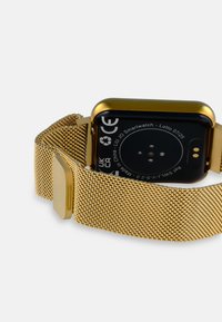 Guld smartwatch med en glat rektangulær urskive, sort bagside og en struktureret guld meshrem. Funktioner inkluderer CE-mærkning og ladekontakter.