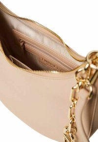 Borsa a mano in pelle beige con una texture liscia, hardware dorato, chiusura a zip e tasche interne, tra cui una sezione con zip e dettaglio del logo.