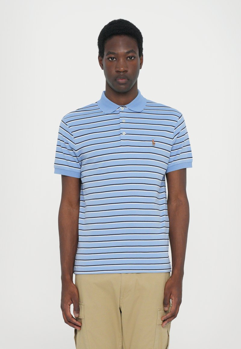 Μπλε ριγέ πόλο μπλούζα με γιακά, κοντά μανίκια και μικρό ραμμένο λογότυπο στο στήθος. Κατασκευασμένη από βαμβάκι με λεία υφή.