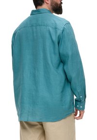 Turquoise linnen shirt met lange mouwen, knoopmanchetten, een relaxte pasvorm en een rugpanddetail, gezien van achteren.
