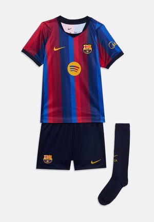 Divisa da calcio del FC Barcellona con maglia a righe verticali blu e rosse, pantaloncini blu navy e calzettoni blu navy con stemma del club e loghi Nike.