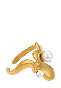 Anello d'oro con un design astratto e ondulato, caratterizzato da due perle bianche di dimensioni diverse su uno sfondo bianco.