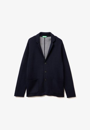 Marineblauer Cardigan aus Wollmischung, mit grauem Innenfutter, abgeschrägtem Kragen, vier schwarzen Knöpfen und zwei Fronttaschen.