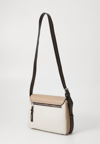 Borsa a tracolla realizzata in pelle liscia. Presenta una parte superiore beige, una parte inferiore bianca e una tracolla marrone con cuciture bianche e una chiusura a zip.