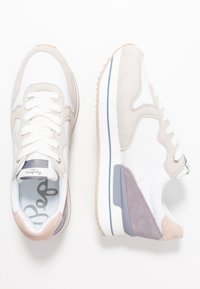 Sneaker bianche e grigie realizzate in suede e pelle. Punta arrotondata, design con lacci, suola texture e sottili accenti di colore.