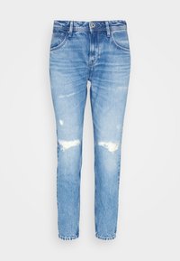 Jeans in denim azzurro chiaro con vestibilità affusolata, caratterizzati da toppe sdrucite sulle ginocchia, una leggera scoloritura e un orlo grezzo alla caviglia.