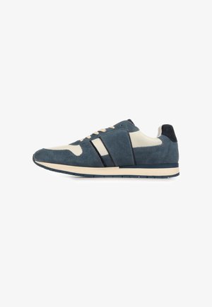 Laag model sneaker in blauw suède en wit leer met crème veters, beige tussenzool en donkerblauwe rubberen buitenzool, zijaanzicht tegen een witte achtergrond.
