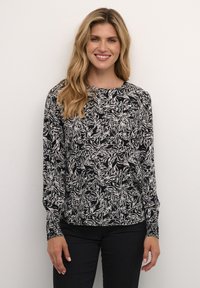 Blusa a maniche lunghe con motivo floreale in bianco e nero, realizzata in tessuto morbido. Presenta un colletto tondo e polsini elasticizzati.