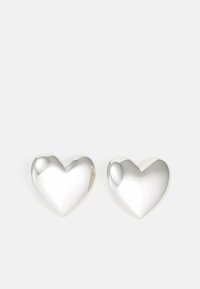 Pendientes de plata en forma de corazón con una superficie lisa y reflectante. Bordes redondeados y un suave surco en la parte superior. Diseño ligero.