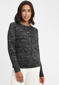 Pull long à manches longues en marron et noir avec un col rond et des poignets côtelés. Le tissu semble doux avec une légère texture. Marque discrète au bas.