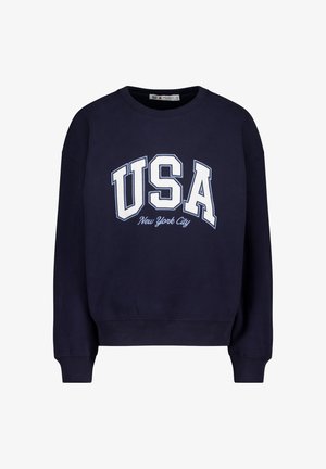 Sweat-shirt bleu marine avec "USA" et "New York City" imprimés en lettres majuscules blanches. Dispose d'un col rond côtelé et de poignets côtelés. En matériau doux en mélange de coton.