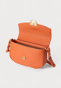 Orange textured leather crossbody bag with adjustable strap and flap open showing gold-tone magnetic clasp and interior.