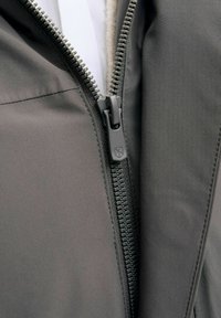 Must mustriga jakk sileda, mattpinnaga kanga ja metallist tõmblukuga. Tõmblukk on täielikult suletud, avades pehme sisekuue.