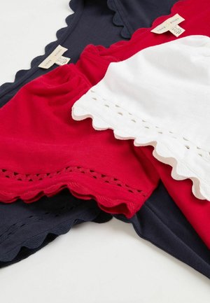 Tri majice v mornarsko modri, rdeči in beli bombaž, z valovitimi robovi. Rdeča in bela majica imata okrasne očesne čipke vzdolž roba.