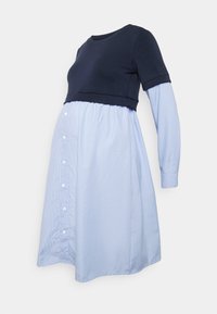 Maternity dress with a navy top and light blue striped skirt. Features a round neckline, long sleeves, and button detailing on the side.