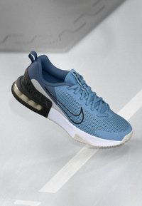 Light blue athletic shoe with mesh upper, black accents, and a transparent heel. Features laces, padded collar, and a textured sole.