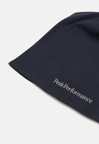 Navy cotton beanie featuring a soft texture, folded design, and a subtle embroidered "PeakPerformance" logo in light color.