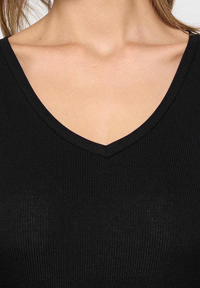 Czarny prążkowany top bez rękawów z dekoltem w kształcie litery V, charakteryzujący się gładką teksturą i dopasowanym krojem, podkreślającym górną część ciała.
