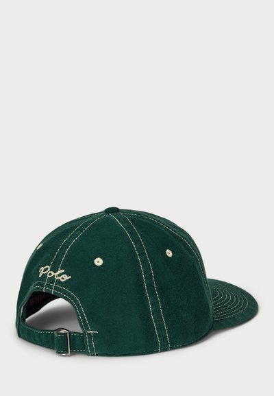 Casquette en suede vert avec couture blanche, visière courbée et logo "Polo" brodé à l'arrière. Sangle ajustable pour le réglage.