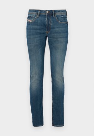 Blue denim jeans with a slim fit, featuring a button closure, classic five-pocket design, and slight fading along the legs for a worn appearance.