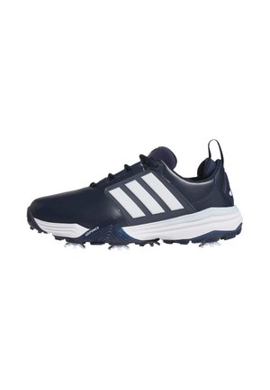 Zapato de golf Adidas azul marino con rayas blancas, suela blanca y tacos de punta, mostrado de lado sobre un fondo blanco.