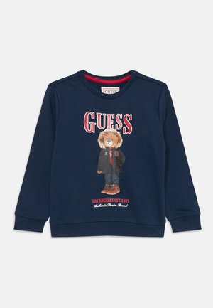 Navyblauwe sweatshirt van katoen, met een beerafbeelding in een jack en de tekst "GUESS" en "LOS ANGELES EST. 1981" eronder gedrukt.