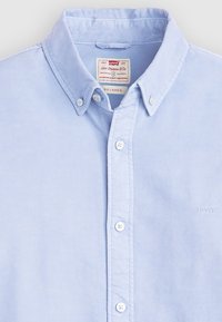 Lichtblauwe overhemd met lange mouwen van katoen. Heeft een button-down kraag en een klein geborduurd logo op de borst.