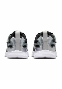 Svart mesh sneakers med sølvdetaljer, hvite såler og en løflet ved hælen. Har ventilasjons hull på sidene for pusteevne.