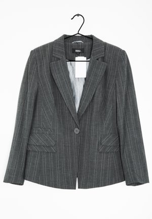 Dunkelgraues Nadelstreifen-Sakko mit Revers, Ein-Knopf-Verschluss und zwei Klappentaschen, an einem schwarzen Kleiderbügel vor weißem Hintergrund hängend.