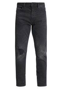 Mustat farkut, joissa on lievää kulutusta ja reikä edessä; perinteinen viiden taskun malli; vetoketjullinen haarakiinnitys ja vyölenkit.