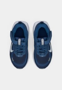 Σκοτεινά μπλε αθλητικά παπούτσια με διχτυωτό ύφασμα, υφή σχεδίασης, λευκές λεπτομέρειες και κορδόνια, που διαθέτουν ιμάντα με βέλκρο για ασφαλή εφαρμογή.
