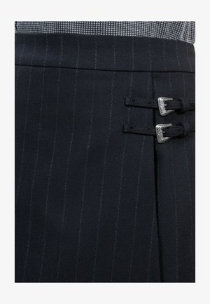 Zwarte streepjesrok gemaakt van gestructureerde stof met zilveren hardwareaccenten en twee gespsdetails aan de zijkant.
