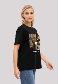 Black T-shirt featuring a collage of four vintage-style images and the text "LET IT BE" in white. Cotton material, relaxed fit.
