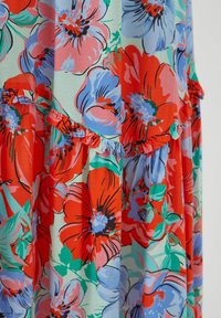 Vestido floral con un fondo azul claro decorado con vibrantes flores rojas y moradas, acentuado por bordes rizados y una tela texturizada.
