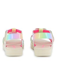 Δύο ζευγάρια σανδάλια με γυαλιστερό, ολογραφικό πάνω μέρος, ροζ λεπτομέρειες και μπεζ σόλα. Διαθέτουν λουράκια με βέλκρο για ασφαλή εφαρμογή.