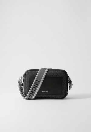 Schwarze Umhängetasche mit einem strukturierten Stoffkörper, glattem Lederfront und einem kontrastierenden Riemen mit "MICHAEL KORS"-Branding.