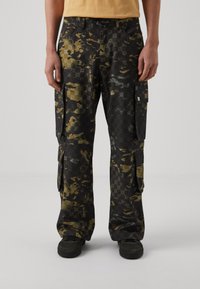Cargo bukser i sort med et camouflage mønster, der indeholder nuancer af grøn og grå. Inkluderer flere sidelommer og en afslappet pasform.
