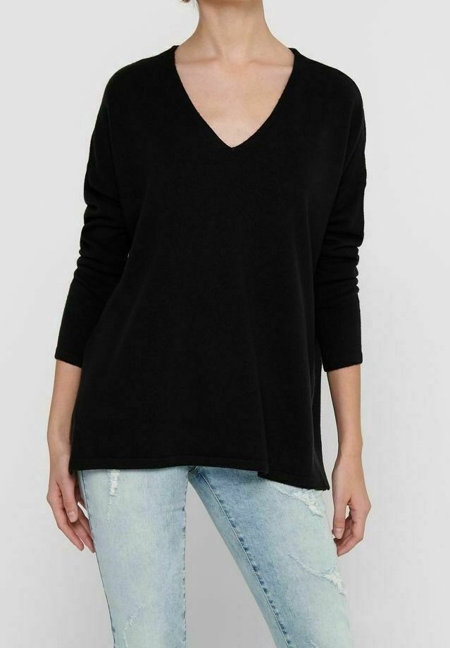 Pull à col en V noir à manches longues avec une coupe décontractée, fabriqué dans un matériau doux. Associé à un jean bleu clair déchiré. Design simple et polyvalent.