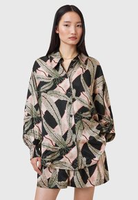 Camicia di seta nera con motivo floreale, caratterizzata da maniche ampie, una chiusura con bottoni davanti e colori a contrasto di verde, rosa e crema.
