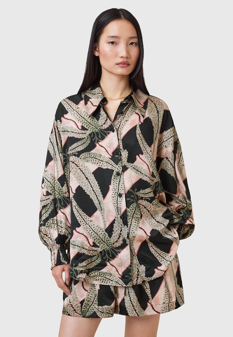 Camicia di seta nera con motivo floreale, caratterizzata da maniche ampie, una chiusura con bottoni davanti e colori a contrasto di verde, rosa e crema.