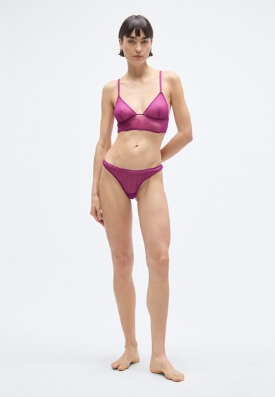 Rózsaszín bralette és hozzá illő bikini szett, texturált anyagból, vékony pántokkal és formázott kialakítással, kiemelve a testhez simuló sziluettet.