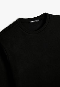 Schwarzer gerippter Sweatshirt mit Rundhalsausschnitt. Verfügt über eine glatte Textur und eine reguläre Passform. Enthält ein Etikett mit dem Markennamen im Kragen.