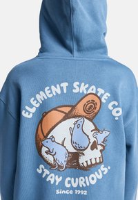Blå hoodie med en tecknad grafisk design av ett björnskalle och smådjur, med texten "ELEMENT SKATE CO." och "STAY CURIOUS."