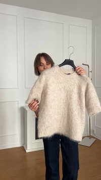 Sweater court à manches courtes beige clair en matière douce et pelucheuse ; encolure ronde, coupe décontractée, ourlet arrière légèrement plus long.