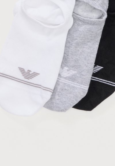 Τρία αόρατα κάλτσες σε λευκό, γκρι και μαύρο, κάθε μία με ένα μικρό ριγωτό λογότυπο κοντά στην περιοχή των δαχτύλων.