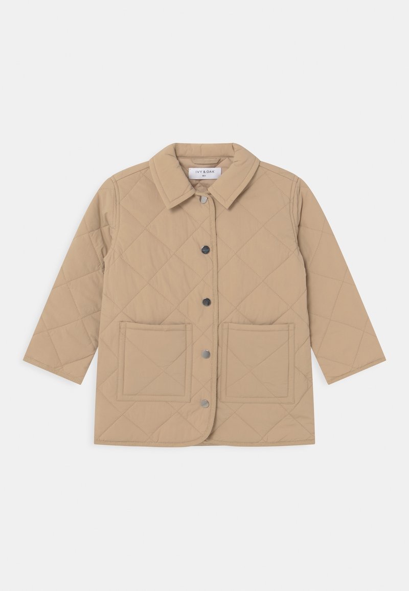 Veste matelassée beige avec fermeture à bouton, col montant et deux grandes poches avant. Elle présente un tissu lisse et léger.