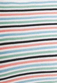 Pestrý pletený materiál s pruhy ve širokých horizontálních pruzích bílé, černé, zelené, modré, korálové a světle růžové barvy s měkkou texturou.