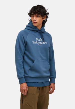 Blauer Kapuzenpullover mit Kängurutasche, gerippten Bündchen und verstellbarem Kapuzenzug. Mit "Peak Performance"-Logo in Weiß. Glatte Stofftextur.