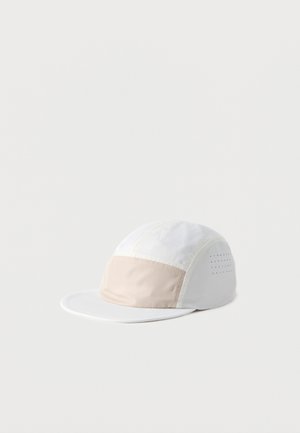 White and light beige panel cap with a flat brim and small vent holes on the side for breathability.