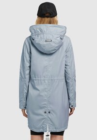 Parka bleu clair à capuche avec taille cintrée, poignets élastiques et fermetures à pression à l'ourlet. Tissu lisse et résistant à l'eau.